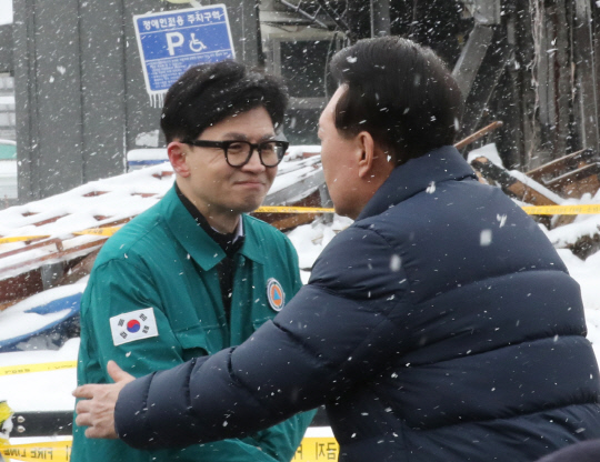 지난 1월23일 윤석열 대통령이 충남 서천군 서천읍 서천특화시장 화재 현장에서 한동훈(왼쪽) 국민의힘 비상대책위원장과 만나 인사하고 있다.<연합뉴스>